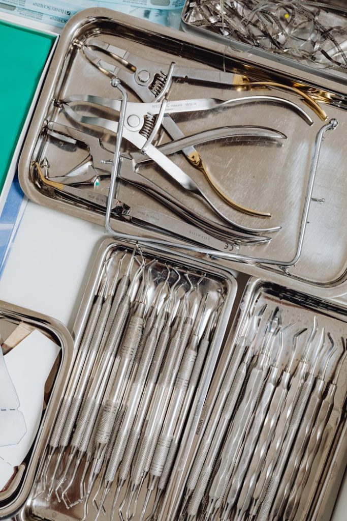Close-up of organized dental instruments in stainless steel trays, ideal for medical use.
