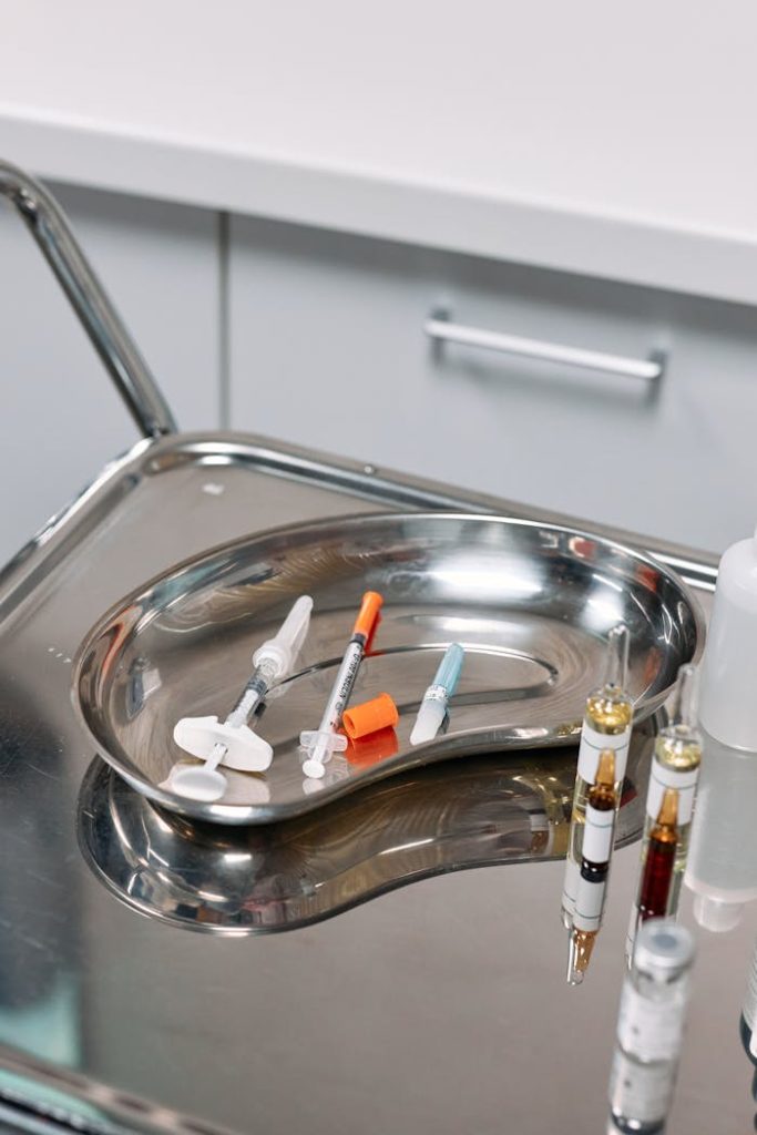 Close-up of syringes and medical tools on a silver tray. Ideal for healthcare and medical themes.